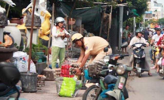 CSGT dùng tay bốc trứng vỡ giúp dân gây xúc động