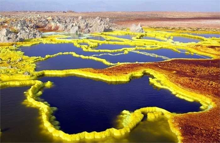 Dallol, Ethiopia. Khu vực ngay gần núi lửa đã ngừng hoạt động trong thời gian qua và là nơi sở hữu nhiệt độ khủng khiếp với mức trung bình hơn 41 độ C trong suốt gần 100 năm qua. Ngoài ra, Màu sắc tươi sáng và rực rỡ xuất hiện xung quanh khu vực miệng núi lửa như màu trắng, vàng, đất son, xanh lá cây và đỏ là do có sự kết hợp của những con suối nước nóng, núi lưu huỳnh, hồ axit, hồ oxit sắt, lớp muối ẩn. Không ngạc nhiên khi gần như không có người ở tại đây