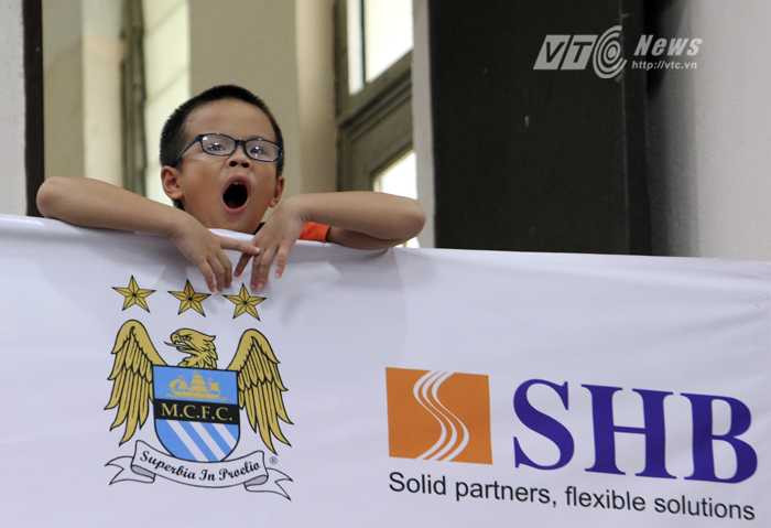 Một fan nhí ngáp dài khi chờ sự xuất hiện của các cầu thủ Man City trong hội trường Đại học Ngoại ngữ Quốc gia Hà Nội (Ảnh: Hà Thành)