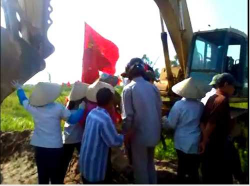 Người dân đứng chặn không cho chiếc máy xúc tiến vào thi công - Ảnh cắt từ clip 
