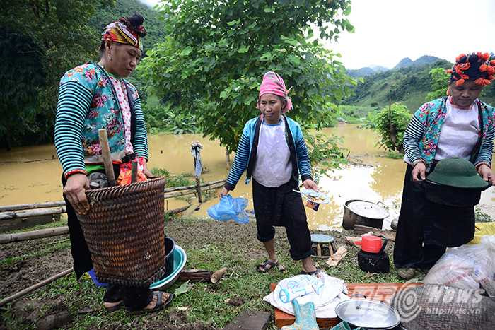 Chị Muồng Thị Dận (36 tuổi) cùng những người phụ nữ khác trong bản đang cố gắng tận dụng chút lương thực, vật dụng vớt lên được sau trận lũ để nấu ăn cho qua ngày.