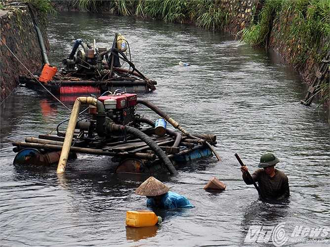 Nhiều người dân vẫn lội dưới dòng nước đen kèm theo váng dầu, than để lấy than từ dưới lòng kênh.