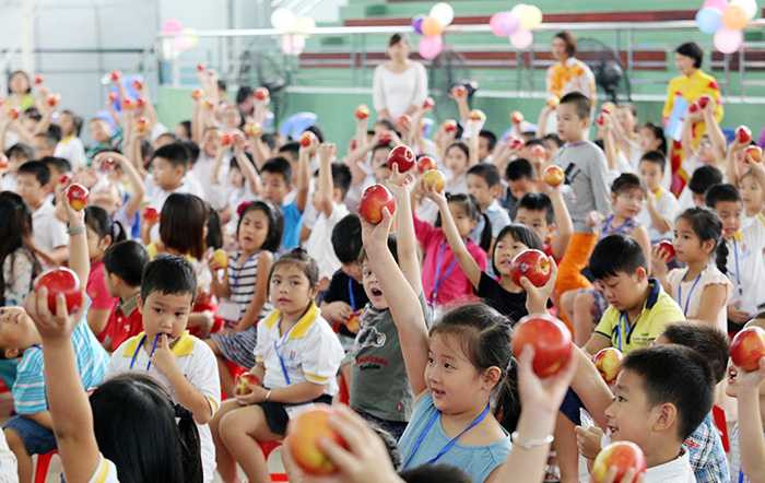 Hào hứng giơ cao trái táo đỏ vừa được nhận