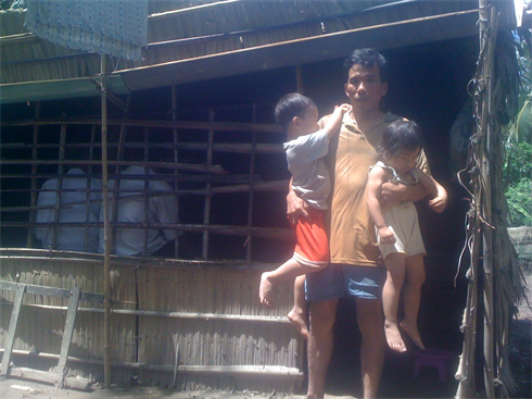 Anh Nguyễn Văn Anh và 2 đứa nhỏ trong căn nhà lụp xụp giữa nghĩa trang