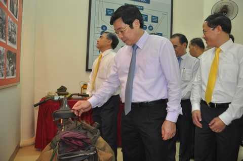 Bộ trưởng Nguyễn Bắc Son bồi hồi trước chiếc xe đạp dùng để vận chuyển thư từ, công văn, là di vật của một thời tại Nhà truyền thông Khu căn cứ Ban Giao bưu vận và Ban Thông tin liên lạc Trung ương Cục miền Nam.