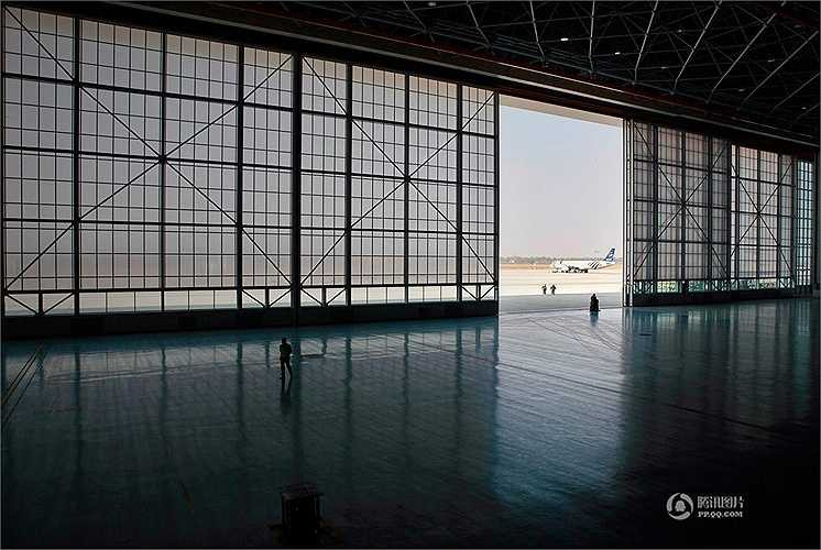 Máy bay được đưa ra khỏi khu vực sửa chữa. Hình dạng ngôi nhà rộng, cao đủ sửa chữa nhiều máy bay cùng lúc