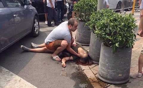 Hình ảnh cho thấy một người đan ông nước ngoài đỡ cô gái sau khi bị đâm