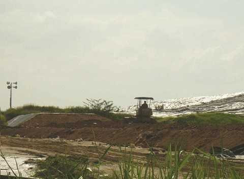 Xe ủi đang san lấp một đoạn bờ đê mới trong kế hoạch mở rộng khu vực chứa rác. Xe ủi đang san lấp một đoạn bờ đê mới trong kế hoạch mở rộng khu vực chứa rác.