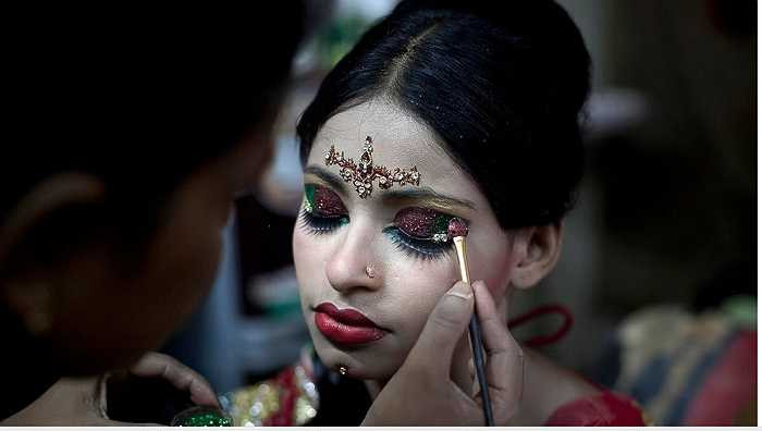 Một người thợ trang điểm cho cô dâu trong ngày cưới