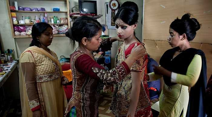 Người thân giúp cô dâu nhí mặc trang phục truyền thống