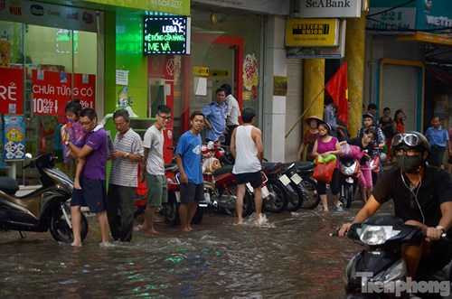 Nhiều người dân đi lên vỉa hè do nước ngập. Nhiều người dân đi lên vỉa hè do nước ngập.