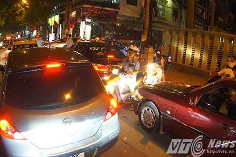 Xe máy len lỏi giữa dòng ô tô để tìm đường thoát ra.