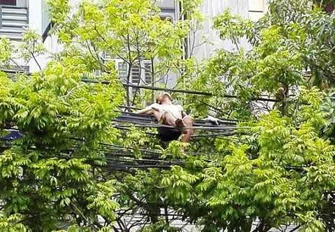 Nam thanh niên cởi trần nằm trên đường dây điện Nam thanh niên cởi trần nằm trên đường dây điện