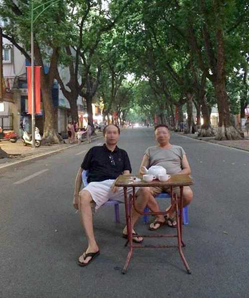 Bức ảnh hài hước 2 người đàn ông ngồi uống trà giữa đường Phan Đình Phùng. (Ảnh: Phạm An)