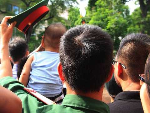 Người lính trẻ âm thầm lấy mũ của mình che cho cháu nhỏ