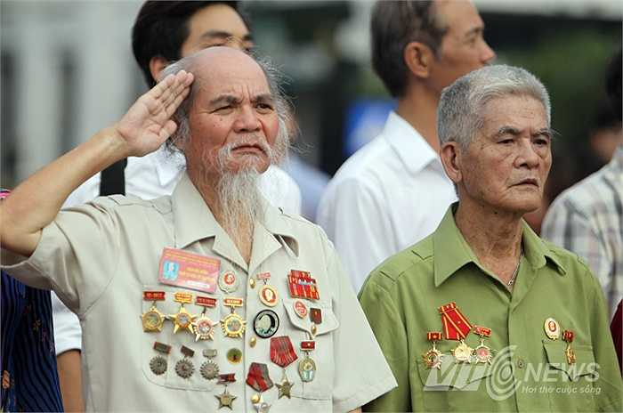 Một cựu chiến binh chào cờ trước quảng trường Cách mạng Tháng Tám.