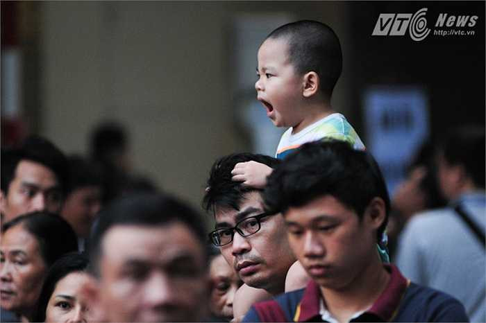 Một em bé ngáp ngủ vì dậy sớm chờ diễu binh