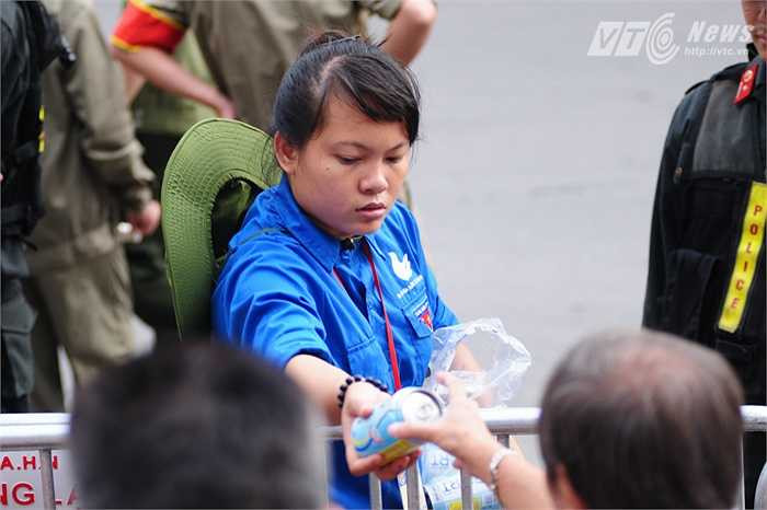 Bạn tình nguyện viên chia nước cho những khán giả lớn tuổi, trẻ em