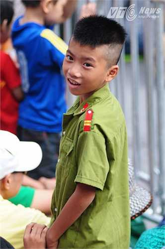 Cậu bé được mặc bộ quần áo công an hồ hởi chờ xem diễu binh (Tùng Đinh/Thực hiện)
