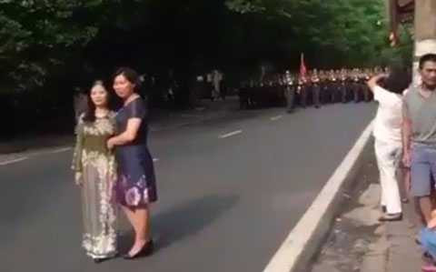 Người dân xuống đường chụp ảnh cùng đoàn diễu binh (Ảnh cắt từ clip)