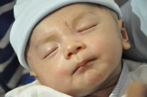 Bé Dương Minh Phát bụ bẫm, ngủ ngon lành trong tay mẹ (Ảnh: Pháp luật TP.HCM)