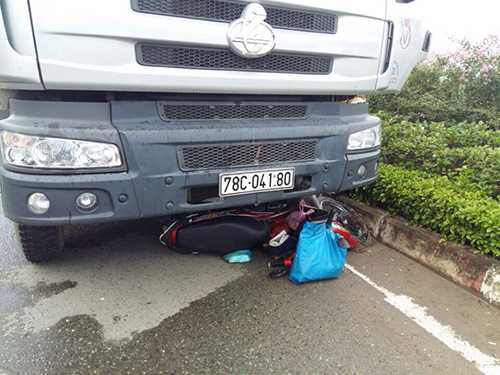 Chiếc xe máy bị cuốn vào gầm xe tải