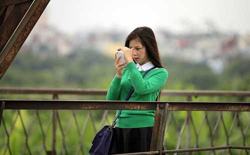 Một bạn trẻ dạo chơi trên cầu Long Biên với áo len
