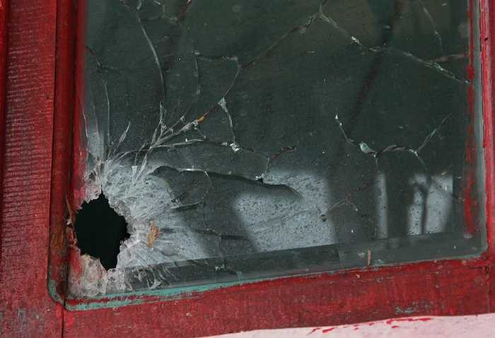 Vết bắn làm thủng kính tàu của tài công Huỳnh Văn Tửng (45 tuổi). Anh này cho biết, trên tàu có 19 người đang đánh bắt cá ở vùng biển giáp ranh giữa Việt Nam - Thái Lan - Malaysia, bất ngờ nhóm 10 người đi trên canô có trang bị vũ khí rượt đuổi nả đạn. 