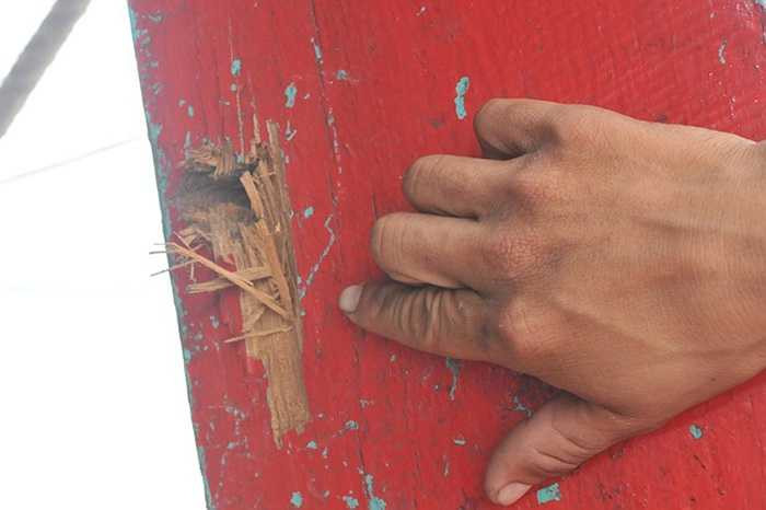Mạn tàu cá của anh Tửng ghim vết đạn. 'Khoảng một giờ sau, khi hay tin có người trúng đạn chết, chúng đã thả tôi cùng 18 thuyền viên lái tàu về', tài công này cho biết.