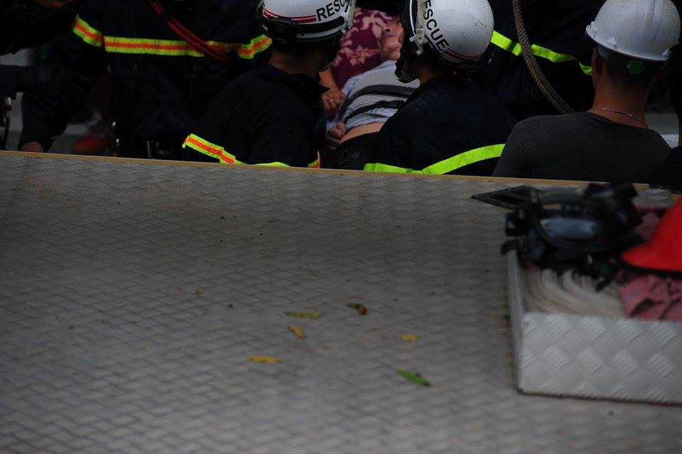 Một người dân bị ngạt khói được đưa xuống theo đường thang bộ.