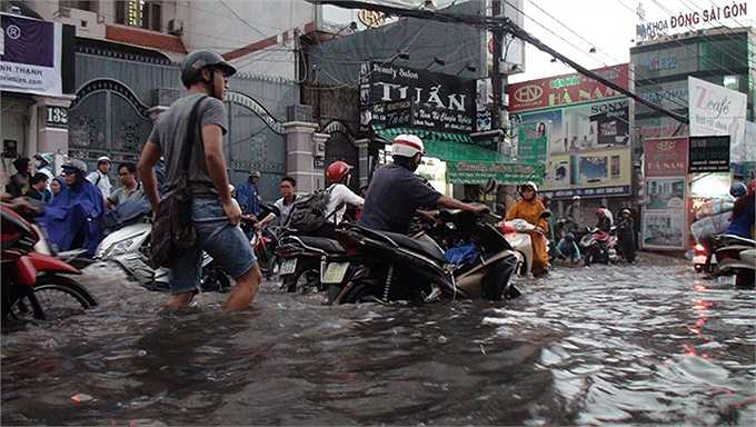 Người dân lội nước cống đen ngòm trên đường - Ảnh: Đức Phú