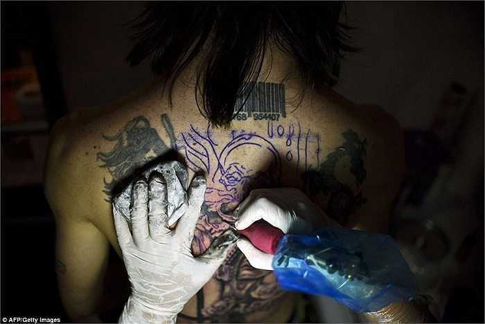 Một người phụ nữ thêm những hình xăm mới trên lưng của mình