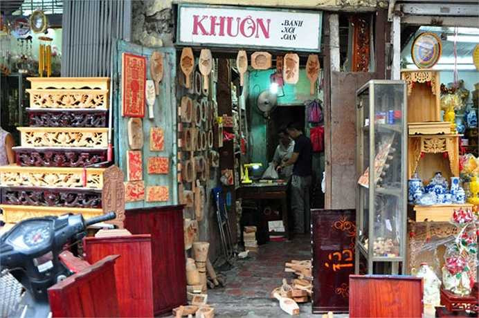 Cửa hàng của ông Quang rộng chừng 10m2, nằm nép mình trên một góc phố Hàng Quạt. Phía trước cửa hàng treo tấm biển hiệu đơn sơ với dòng chữ Khuôn: bánh, xôi, oản.