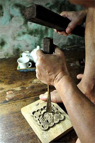 Trên tấm phản kê ở góc nhà, người đàn ông tuổi lục tuần vẫn đang cặm cụi đục, đẽo, hoàn thiện nốt chiếc khuôn bánh nước hình hoa sen.