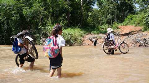 Để kịp lịch học chiều, từ 9-10g sáng, các học sinh từ khối lớp 4 đến lớp 9 phải băng rừng, vác xe qua suối để đến trường ở trung tâm xã Ea Kiết