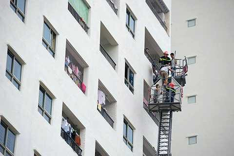 Lực lượng cảnh sát PCCC tiếp cận tầng 12 đưa người bị kẹt xuống đất.