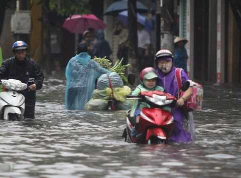 Xe hỏng, người mẹ này lội qua nước ngập đưa con đến trường Xe hỏng, người mẹ này lội qua nước ngập đưa con đến trường
