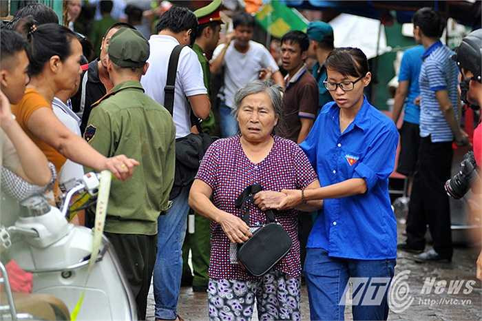 Nhiều cụ già không thể đi lại được người dân dìu dắt ra khỏi khu vực nguy hiểm.