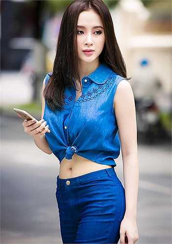 Angela sành điệu và lôi cuốn khi chọn tone xanh denim cho kết hợp crop top buộc vạt và quần ống loe.