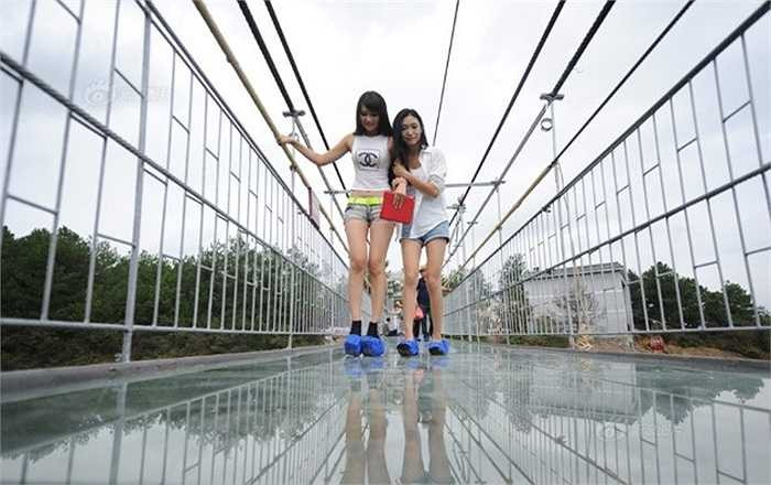 Hai cô gái chụp ảnh kỷ niệm trên cầu