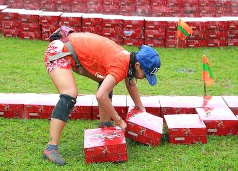 Trong một thử thách khác, đội Cam rất vất vả khi phải xếp những thùng giấy dưới trời mưa rất to.