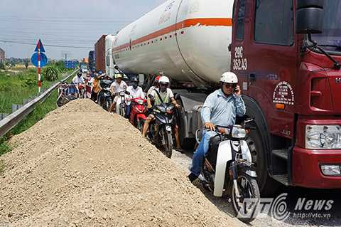 Vật liệu xây dựng đổ bừa bãi chắn hết phần đường dành cho xe máy. Vật liệu xây dựng đổ bừa bãi chắn hết phần đường dành cho xe máy.