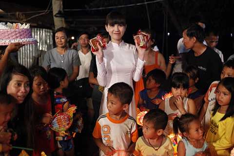 Trong tà áo dài trắng tinh khôi, Ngọc Trinh đã tặng bánh Trung Thu, lồng đèn cho các em và cùng nhau rước đèn.