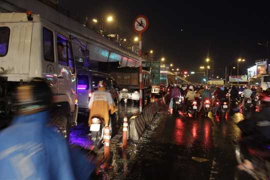 Nhiều xe máy bất chấp nguy hiểm len qua các kẽ hở trên làn đường xe tải hoặc chạy thẳng lên cầu vượt Thủ Đức tìm đường thoát