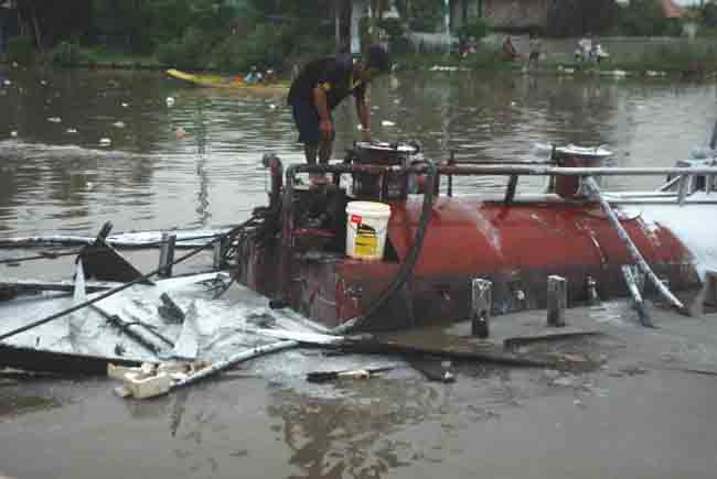 Số dầu trên ghe bị chìm đang được bơm ra ngoài.