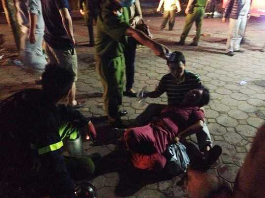 Người dân và lực lượng cứu hộ sơ cứu người bị ngạt khói. Ảnh: Người lao động.