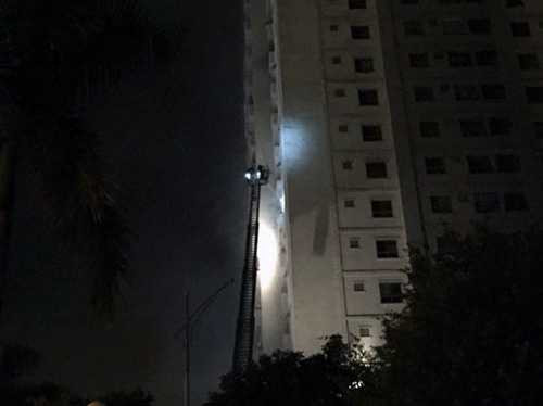 Lực lượng chức năng dùng xe thang tiếp cận những căn phòng nghi có người để cứu hộ - Ảnh Minh Quang.Tuổi Trẻ