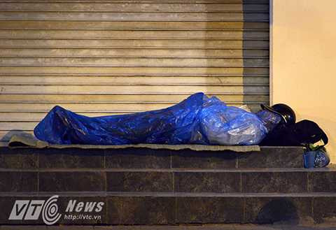 Để chống lại giá lạnh, nhiều người chỉ có một manh áo mưa mỏng.