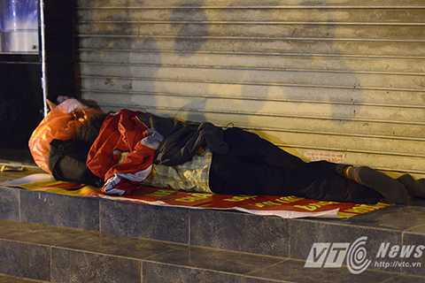 Những cơn mưa nhỏ, kèm theo gió liên tục thổi khiến người đàn ông này nằm co ro quay lưng ra ngoài đường.