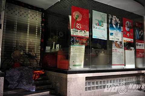 Một người vô gia cư nép sâu vào trong hiên nhà của một cửa hàng trên phố Đinh Tiên Hoàng để tránh gió lùa và mưa rét.